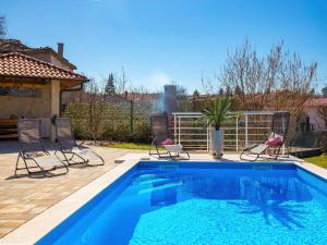 a swimming pool with two chairs and a swimming pool at Villa Lemily in Matulji