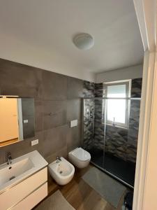 een badkamer met een wastafel, een toilet en een douche bij Appartamento Mare Fuori in Polignano a Mare