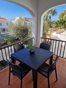 a black table and chairs on a balcony at HOLIDAYS MENORCA Cala Galdana in Cala Galdana