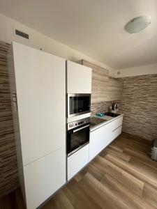 een keuken met witte kasten en een magnetron bij Appartamento Mare Fuori in Polignano a Mare
