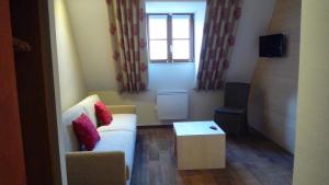a small living room with a couch and a table at Hôtel Winzenberg bed and breakfast in Blienschwiller