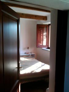 阿格林杜的住宿－Tipico stazzo splendida vista mare，一间卧室设有一张床和一个窗口