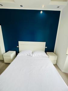 a large white bed in a room with a blue wall at Boutique Rooms in Rome