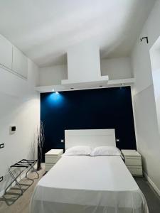 a bedroom with a large white bed with a blue wall at Boutique Rooms in Rome