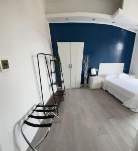 a bedroom with a white bed and a blue wall at Boutique Rooms in Rome