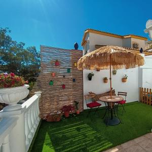 un piccolo patio con tavolo e ombrellone di Villacarmen Suite a Benalmádena