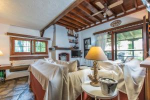 スカラ・フォルカスにあるF & B Summer Collection - Kassandra - Fourkaのソファとランプ付きのテーブルがあるリビングルーム