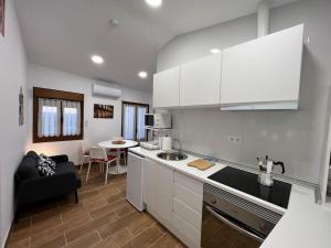 a kitchen with white cabinets and a living room at Atico El Lagar de Labastida in Labastida
