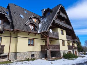 un edificio de apartamentos con techo de gambrel en Apartmán Severanka, en Vysoké Tatry