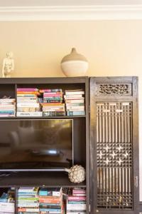 a book shelf filled with books and a lamp at Alphen Drive Apartments in Cape Town