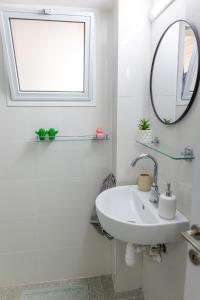 Baño blanco con lavabo y espejo en bloom en Eilat