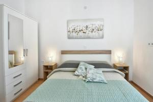 ein weißes Schlafzimmer mit einem Bett und zwei Nachttischen in der Unterkunft Apartment Ariana - central & comfy in Poreč