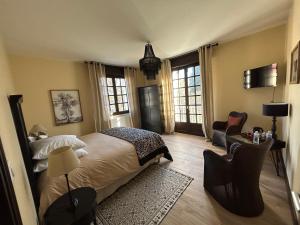 1 dormitorio con 1 cama, 1 silla y ventanas en Domaine de Neuvon, en Plombières-lès-Dijon