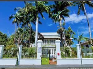聖丹尼斯的住宿－Villa Angélique - Hôtel classé Monument Historique，建筑前有棕榈树的白色围栏