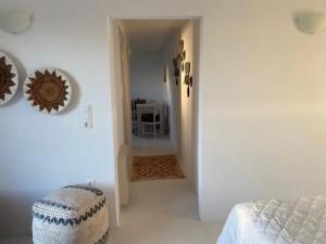 Cette chambre blanche dispose d'un lit et d'un couloir. dans l'établissement Rustic Stone House in the Heart of Folegandros, à Áno Meriá
