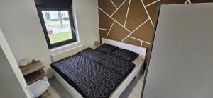 a small bed in a small room with a window at Apartmani KA Sveti Martin in Sveti Martin na Muri