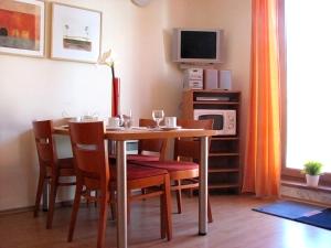 a dining room with a table and chairs and a tv at Apartmán Oščadnica in Oščadnica