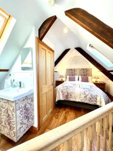 a bedroom with a bed and a sink in a attic at Hectors House, Rothbury in Rothbury