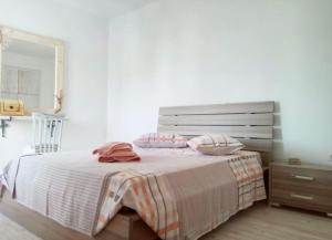 a bedroom with a bed with pink pillows on it at Pebbles Villa with private roof garden in Aliki