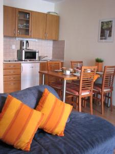 a living room with a blue couch and a kitchen at Apartmán Oščadnica in Oščadnica