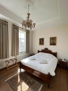 a bedroom with a large bed and a chandelier at De Pastory in Grote-Brogel