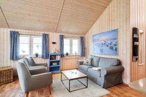 a living room with a couch and a chair at Typ A "Black Pearl" -Kleiner-Belt-Haus- in Pelzerhaken