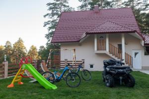 een huis met een fiets en een speeltuin in de tuin bij Rajski Bor Tara 3 galerija in Kaludjerske Bare