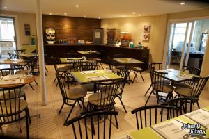 a dining room with tables and chairs in a restaurant at Hotel-Motel Drummond in Drummondville