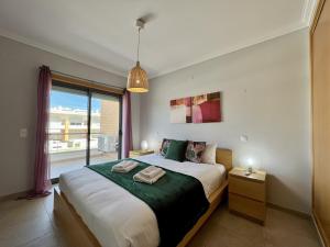 a bedroom with a large bed and a large window at Albufeira Garden Villa With Pool by Homing in Albufeira