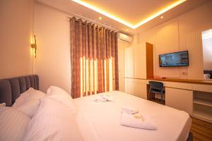um quarto de hotel com uma cama e uma televisão em Hotel Vila Misiri em Durrës