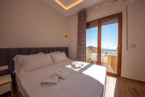 a bedroom with a bed with a view of the ocean at Hotel Vila Misiri in Durrës