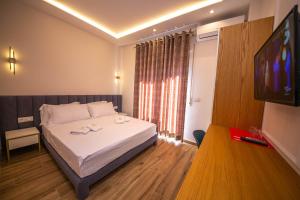 1 dormitorio con 1 cama y TV de pantalla plana en Hotel Vila Misiri en Durrës