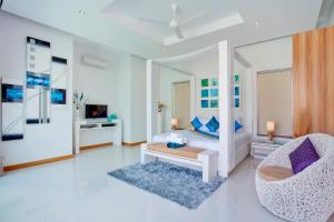 a white living room with a couch and a chair at Sumptuous Modern 3BR Pool Villa Mandala in Ban Saiyuan (1)