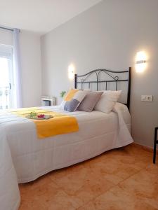 a bedroom with a large white bed with a yellow blanket at HOTEL MAREA in Poio