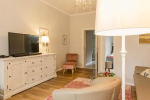 a living room with a television and a white dresser at Villa Morgentau in Zinnowitz