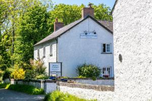 a white building with a sign on the side of it at East Trewent Farm in Pembroke