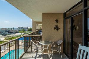 a balcony with a table and chairs and a pool at Laguna Reef #306 - Capm Kens in Rockport
