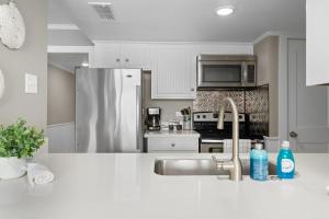 a kitchen with a sink and a stainless steel refrigerator at Laguna Reef #306 - Capm Kens in Rockport +17 photos