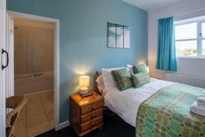 a bedroom with a bed and a night stand with a lamp at East Trewent Farm in Pembroke