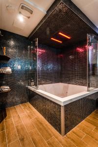 a bathroom with a tub and a glass shower at Olux Hotel-Motel-Suites in Laval