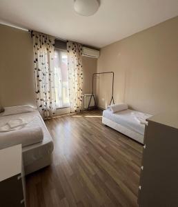 ソフィアにあるLubata 5 Apartments - 2 bedroomsのベッド2台と大きな窓が備わる客室です。