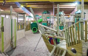 un parque infantil vacío con tobogán y columpios en Gezellig vakantiehuis 't Gramsbergje, en Gramsbergen