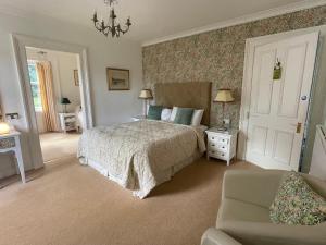 a bedroom with a bed and a couch and a chair at Thistle House Guest House in Saint Catherines