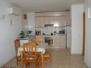 a kitchen with a table and some chairs and a table and a table andktop at Apartamento Cap de Salou in Salou