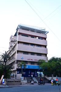 un edificio alto con motos estacionadas frente a él en HOTEL CENTER POINT en Solāpur