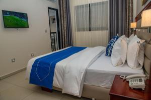 a hotel room with a bed and a phone at Geneva Hotel in Douala