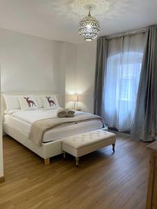 een witte slaapkamer met een groot bed en een kroonluchter bij Ai Tre Garofani B&B in Trento
