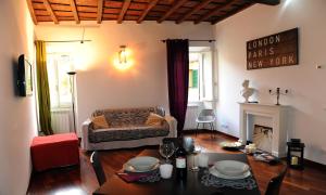 sala de estar con mesa y sofá en Suite Lungara, en Roma