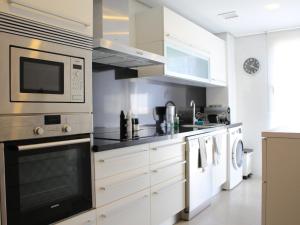 a kitchen with white cabinets and a microwave at The Great Valencia Stay in Valencia