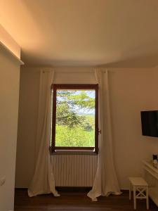 um quarto com uma janela com cortinas brancas em Villa Rina em Pesaro
